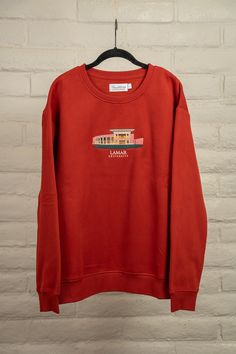 a red sweatshirt hanging on a brick wall