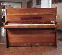 an old piano sitting on the floor in a room