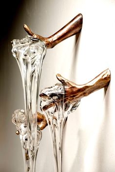 two glass vases with wooden handles on the wall in front of a white background