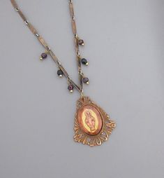 "Vintage Jewelry - Vintage Cameo Necklace - Mother Mary Necklace - Catholic jewelry - One of a Kind Necklace - Religious Jewelry This is such an exquisite vintage one of a kind necklace! This is a beautiful glass cameo image of Mother Mary This delicate piece is from the 1960's with it has a specialty chain and I dangled deep red faceted garnet beads from it.  I'll be adding vintage ladder chain to give it more length.  This is a real special piece.  The pendant is 1 3/4\" long and 1 1/2\" wide Miraculous Medal Pendant Jewelry For Wedding, Wedding Miraculous Medal Pendant Jewelry, Miraculous Medal Wedding Pendant Jewelry, Vintage Miraculous Medal Necklace As Gift, Vintage Miraculous Medal Necklace Gift, Vintage Miraculous Medal Jewelry, Filigree Costume Jewelry Necklace For Gift, Antique Miraculous Medal Pendant Jewelry, Antique Miraculous Medal Necklace As Gift