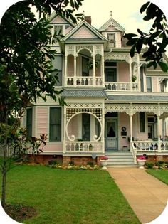 a large pink house with white trim on the front