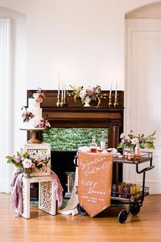 a table topped with a cake next to a fire place filled with candles and flowers