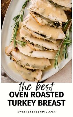 the best oven roasted turkey breast recipe with gravy and herbs on top, in a white plate