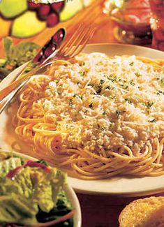 spaghetti with parmesan cheese and salad on the side