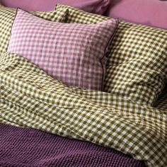 a bed with purple sheets and pillows on it