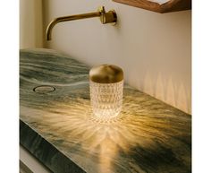 a bathroom sink with a gold colored faucet and soap dispenser