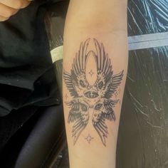 a tattoo on the arm of a person with an owl and stars in their eyes