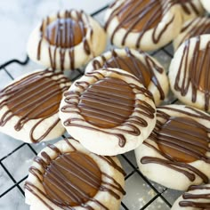 cookies with chocolate drizzled on them sitting on a cooling rack