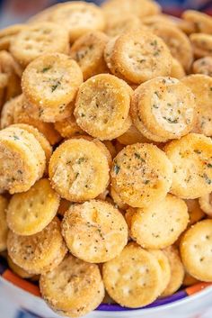 small crackers in a bowl with carrots next to them on a table top