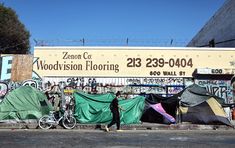 there is a person walking past tents on the street