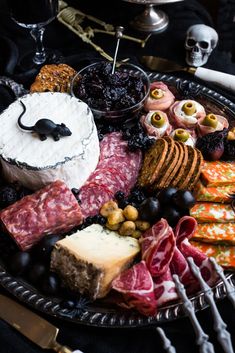 a platter filled with different types of meats, cheeses and crackers