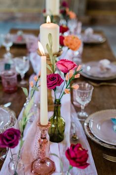 the table is set with flowers and candles