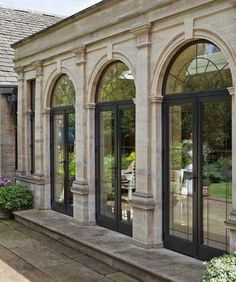 an outside view of a house with many windows and doors on the side of it