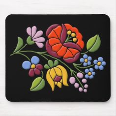 a computer mouse pad with an embroidered flower design on it, and a black background