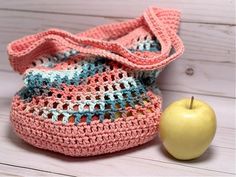 an apple sits next to a crocheted bag