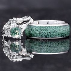 two wedding rings with green and white stones