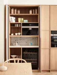 a kitchen with an oven, microwave and wooden shelves in it's center area