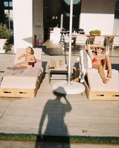 two people laying on lounge chairs in the sun