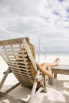 a woman sitting in a chair on the beach