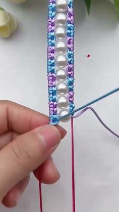 someone is knitting beads on the end of a piece of string