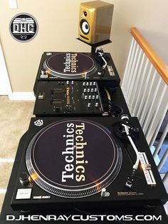 two turntables sitting on top of each other in front of a stair case