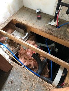 an unfinished bathroom with pipes and plumbing installed in the floor, including water hoses