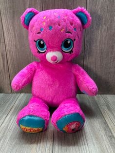 a pink teddy bear with sprinkles on it's face and eyes