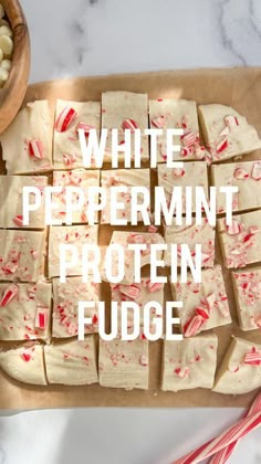 white peppermint protein fudge on a cutting board with candy canes next to it