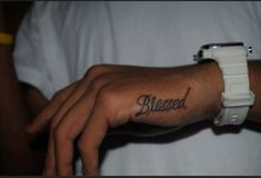 a person with a wrist tattoo that says, blessed