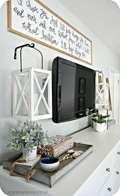 a flat screen tv mounted to the side of a wall next to a white counter