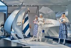 several mannequins are displayed in front of a chandelier with blue and white designs