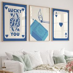 two blue and white posters on the wall above a couch