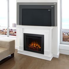 a living room with a fireplace and large window overlooking the cityscape in the background