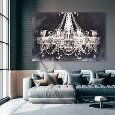 a living room with a couch and chandelier hanging on the wall above it