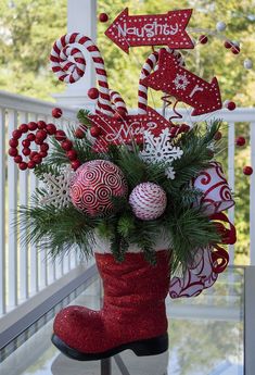 a red boot with christmas decorations and candy canes in it sitting on a porch