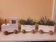 three wooden train planters sitting on top of a white table next to a window