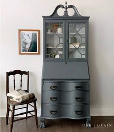 an old china cabinet with glass doors and drawers in front of a chair next to it