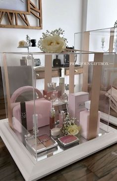 a display case filled with lots of different types of cosmetics and perfumes on top of a wooden table