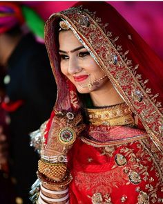 a woman in a red and gold bridal outfit