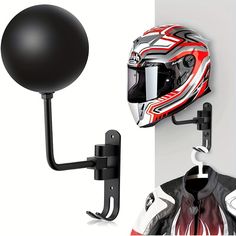 a motorcycle helmet mounted to the side of a white wall next to a black ball