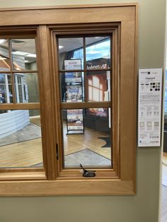 an open window in the corner of a room with wood trim and glass panes