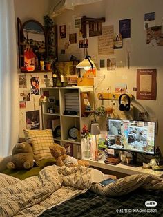 a bedroom with a bed, desk and computer monitor on the wall next to it