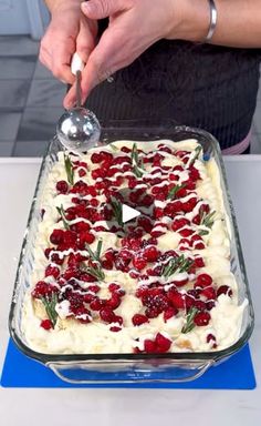 a person is spreading icing on top of a dessert in a glass baking dish