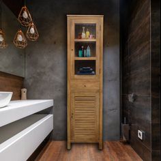 a wooden cabinet sitting in the middle of a bathroom