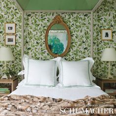 there is a bed with white pillows and green wallpaper on the headboard in this bedroom