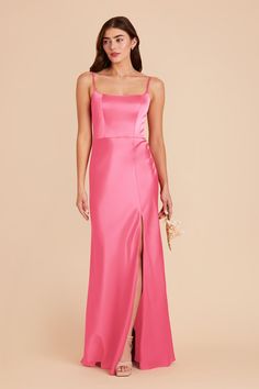 a woman wearing a pink dress with an asymmetric slit