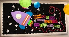 a bulletin board decorated with paper stars and a rocket ship