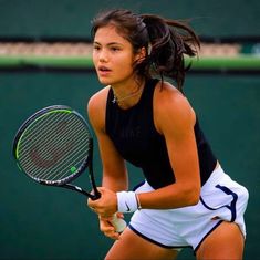 a woman holding a tennis racquet on a court