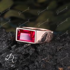 a red stone ring sitting on top of a rock