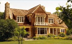 a large brown brick house sitting on top of a lush green field